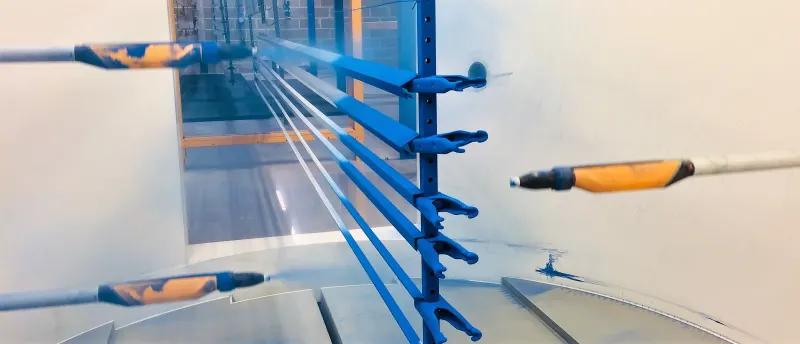 Automated powder spray guns coating blue aluminium extrusions